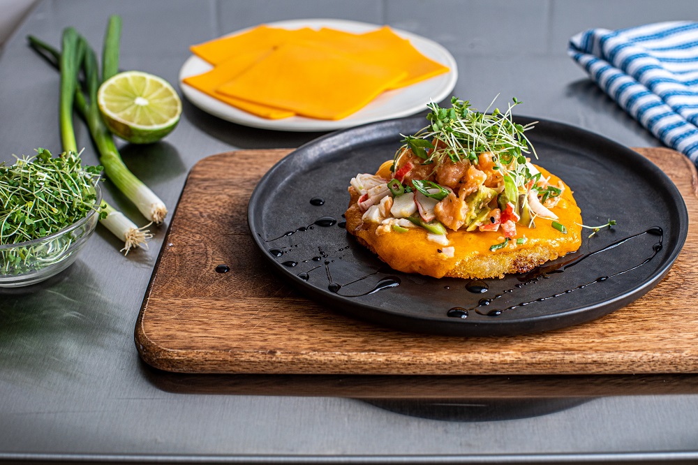 Sushi pizza with salmon tartar, avocado and cheddar